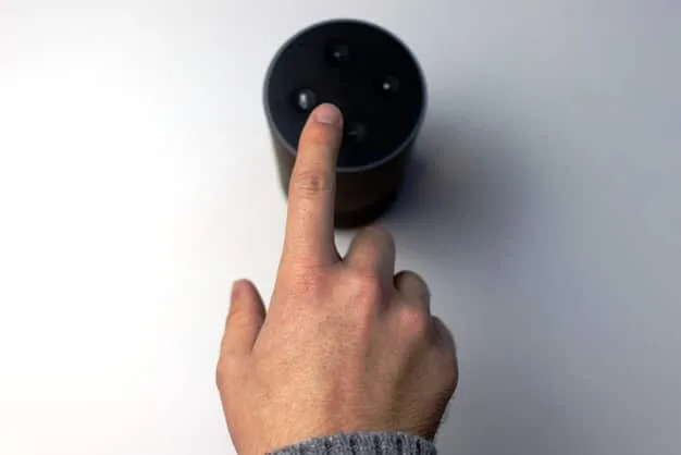 A person's hand pressing a mute button on a smart speaker, illustrating a direct action to enhance privacy.
