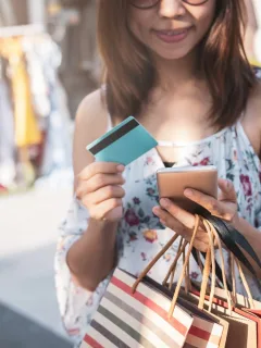 Woman holding her Prepaid Card while doing shopping.