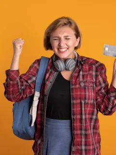 A happy girl holding her Discover it Student Cash Back.