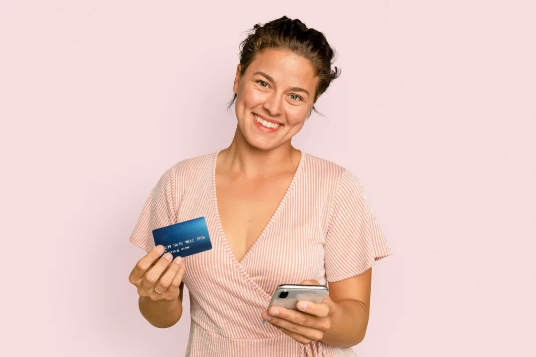A happy woman holding her United Explorer card.