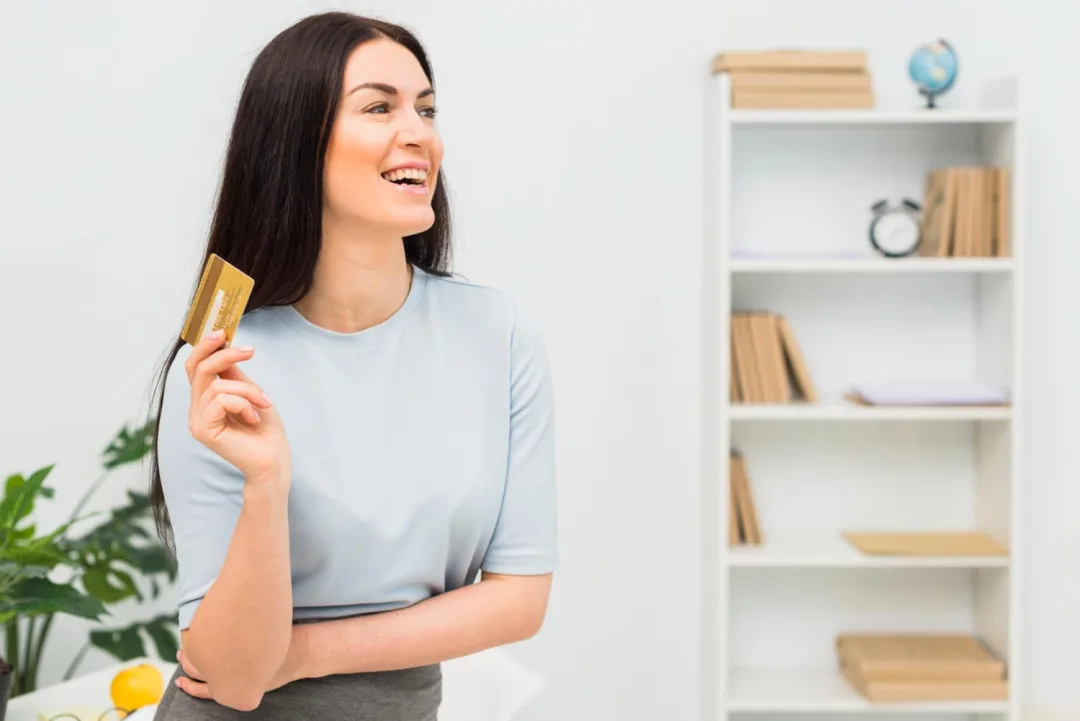 Woman holding a Delta SkyMiles Gold American Express card.