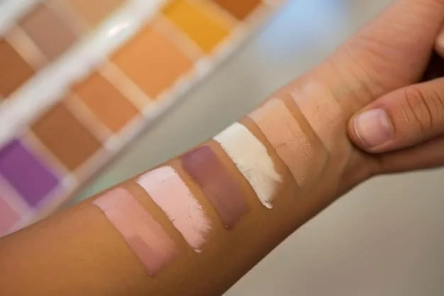 A makeup artist's hand swatching various shades of liquid concealer on a diverse range of skin tones, illustrating the subtle differences in undertones and depth, in a well-lit studio setting.