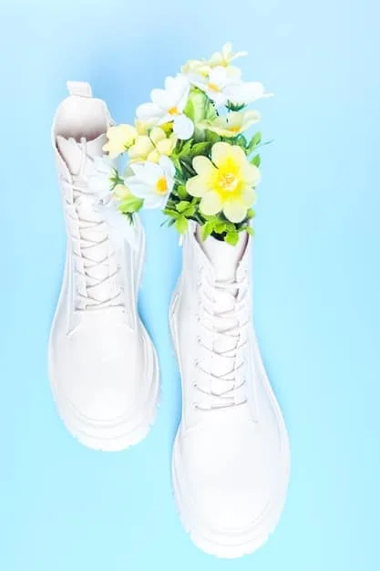 A detailed flat lay of various fashionable footwear options for athleisure, including clean white leather sneakers, stylish black loafers, and sleek low-heeled ankle boots, arranged aesthetically.