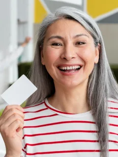 A woman holding a CareCredit Card.