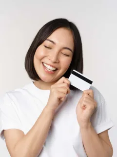 A happy woman holding her US Bank Cash Visa Signature.