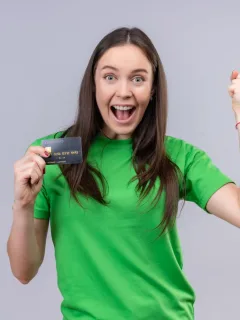 A happy woman holding her TD Cash Credit Card.