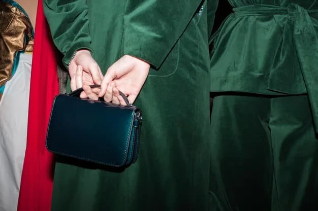 A stylish woman in a dark green velvet jumpsuit at a cocktail party, holding a small clutch, with soft, ambient lighting. Her posture is relaxed but elegant.