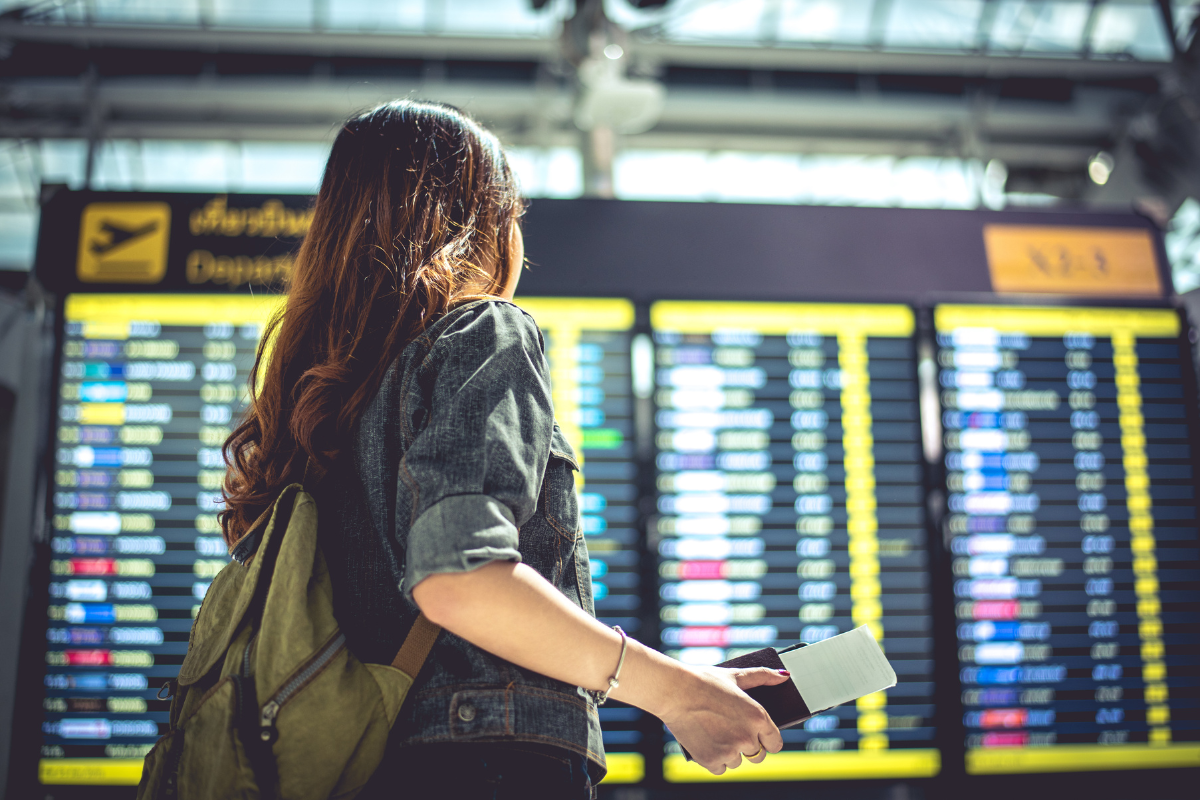 Jovem em aeroporto viajando pelo Voa Brasil.