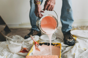 Pessoa misturando tinta com equipamentos ao descobrir como pintar a casa sem erros.