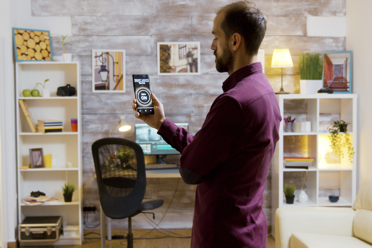 Homem usando a tecnologia na decoração com celular.