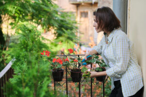 Mulher cuidando de plantas ao saber como montar um jardim pequeno. 