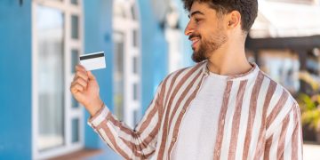 A happy guy learning the Benefits of Using a Credit Card.