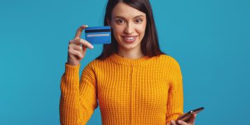 Woman holding her Capital One Platinum Secured Card.