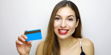 Woman holding her Capital One Platinum Secured.