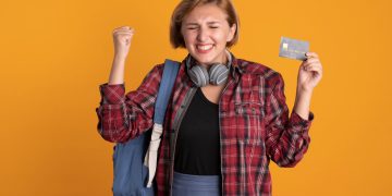 A happy girl holding her Discover it Student Cash Back.