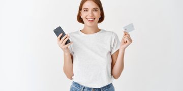 Woman holding her Mission Lane Visa card.