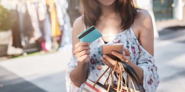 Woman holding her Prepaid Card while doing shopping.