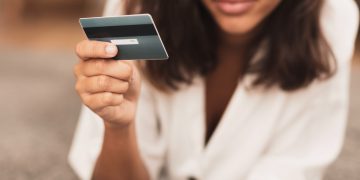 Woman using her QuicksilverOne Capital One Card.