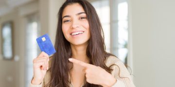 Woman holding her Self Visa Secured Card.