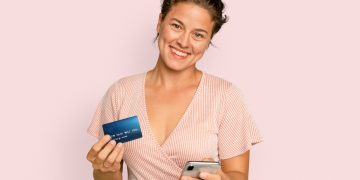 A happy woman holding her United Explorer card.