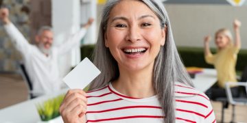 A woman holding a CareCredit Card.