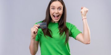 A happy woman holding her TD Cash Credit Card.