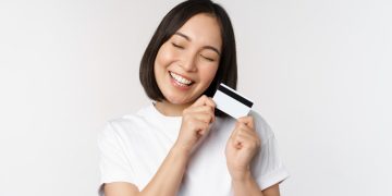 A happy woman holding her US Bank Cash Visa Signature.