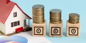 illustrative image with miniature house and coins for home equity line of credit.