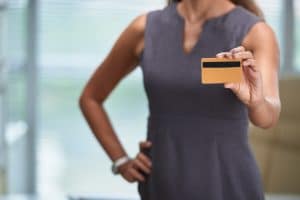 woman holding a card while talking about us credit card deliquencies. 