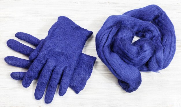 Overhead shot of a dark blue cotton t-shirt tightly bound with rubber bands in a spiral pattern, ready for bleach application. Includes hands in rubber gloves.
