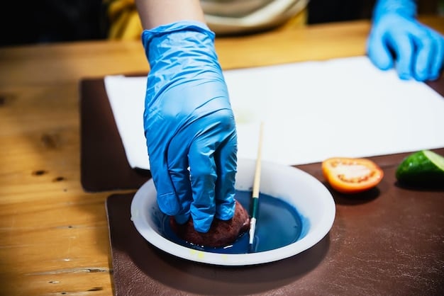 Close-up of a person's hands wearing blue nitrile gloves, carefully mixing clear epoxy resin in a plastic cup with a wooden stir stick, showing the resin's smooth consistency.