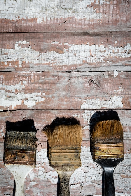 A close-up of a DIY enthusiast sanding a piece of reclaimed barn wood, revealing its rich grain, with various hand tools neatly arranged in the background, suggesting preparation for a project.