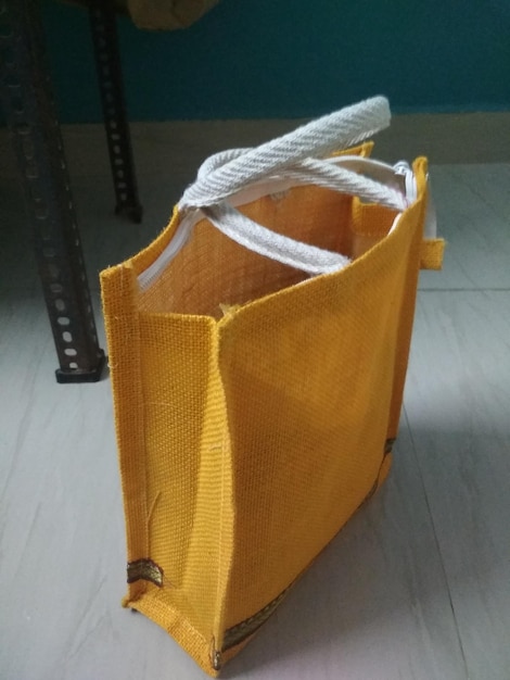 A finished reversible tote bag standing upright, showcasing its crisp topstitched edge and sturdy handles. One side of the bag is visible, with a hint of the contrasting inner fabric peeking from the top. The background is softly blurred to keep focus on the bag.