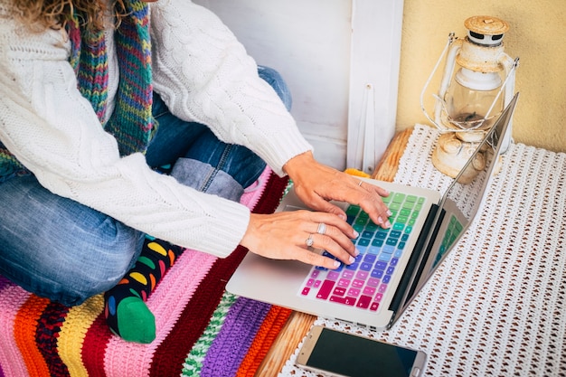 A close-up of a computer screen displaying various digital fabric swatches and color palettes, with a hand hovering over a mouse, ready to drag and drop elements onto a mood board.