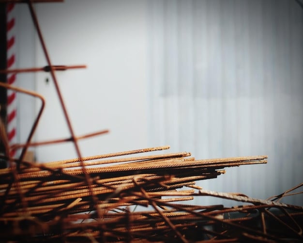 A close-up shot of various construction materials, including rebar, lumber stacks, and bags of cement, neatly organized at a US construction site with safety equipment visible.