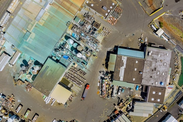 A drone shot showing a sprawling construction site from above, with numerous ongoing projects and a busy flow of trucks delivering construction materials in the US, highlighting logistics.
