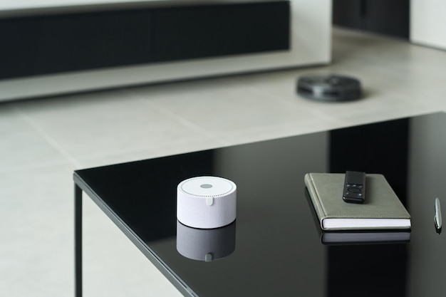 A sleek, modern smart home office showing a clean desk setup with a voice-activated smart speaker, integrated wireless charging pad, and smart lighting that illuminates the desk area with a soft, warm glow.