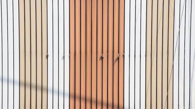 A close-up of a wall featuring slatted wooden acoustic panels, with natural light highlighting their texture.