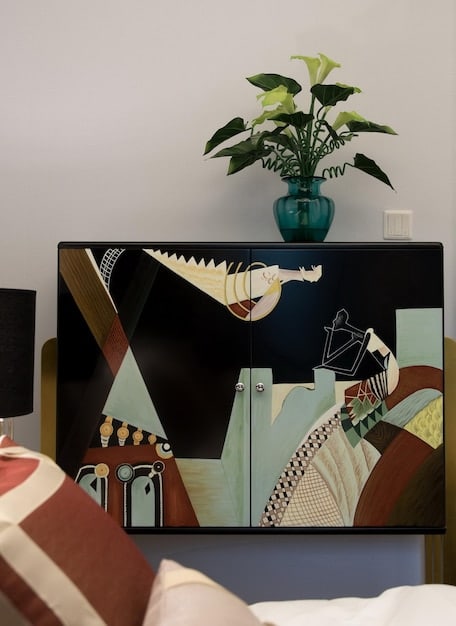 A living room showcasing a large smart display on the wall, exhibiting a digital art piece that matches the room's contemporary decor.