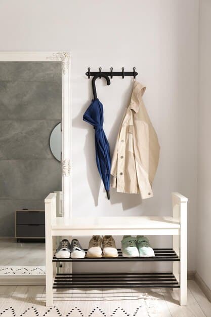 A minimalist entryway with a small bench for seating, a neatly organized wall-mounted coat rack, and a few well-placed decorative items, emphasizing clean lines and functionality.