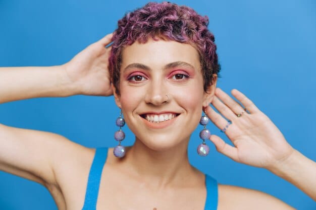 A close-up of a woman with cool-toned skin showing off a vibrant, blue-based red lipstick, her smile enhanced by the flattering shade, alongside swatches of various cool-toned pinks and berries.
