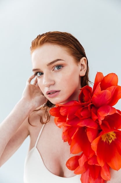 A woman with neutral skin tone showcasing a perfectly balanced true red lipstick, radiating confidence and timeless elegance, with neutral-toned nudes and rose swatches nearby.