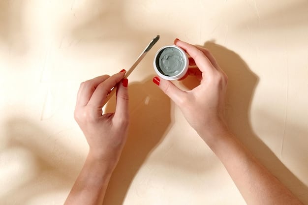 A close-up of a hand holding a fine-tip eyeliner brush poised over an open pot of black gel eyeliner, with a clean, well-lit background.