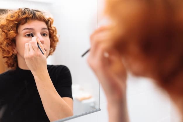 A close-up of a person gently using a cotton swab with precision to correct a small smudge of eyeliner on the outer corner of their eye, with other makeup tools blurred in the background.