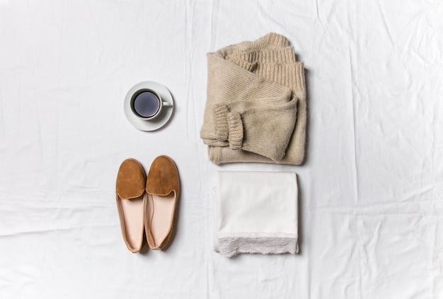 A flat lay of the seven essential capsule wardrobe pieces: a crisp white t-shirt, tailored black trousers, classic medium-wash jeans, a cozy neutral-colored cardigan, a versatile black knee-length dress, a sharp structured black blazer, and clean white sneakers, all neatly arranged.