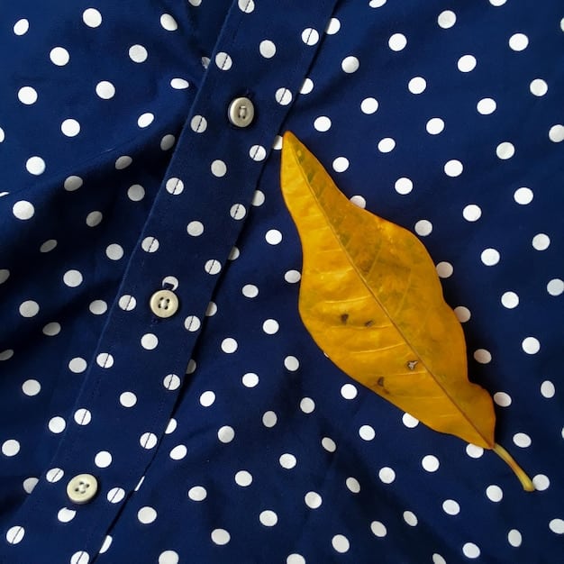 A flat lay of a fashion ensemble showcasing mixed prints: a delicate floral scarf, a classic striped tee, and a polka dot handbag, all unified by a shared color (navy).