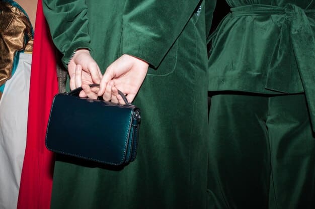 A stylish woman in a dark green velvet jumpsuit at a cocktail party, holding a small clutch, with soft, ambient lighting. Her posture is relaxed but elegant.