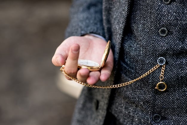 Close-up of a woman's hand adjusting a delicate gold necklace over a charcoal grey power suit, with a glimpse of a sleek watch.