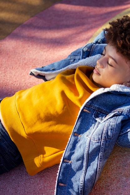 A young person wearing an oversized vintage hoodie and baggy jeans, accessorized with a small shoulder bag and chunky sneakers, in a cozy, relaxed setting.