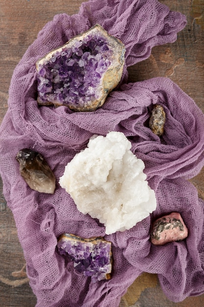 A close-up of a statement necklace crafted from recycled silver and adorned with ethically sourced, raw moonstone and amethyst crystals, resting on a textured, natural linen fabric.